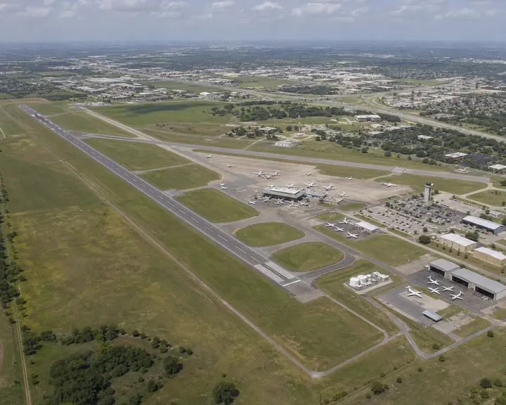 Aerial view of a midsize regional airport beside a highway corridor