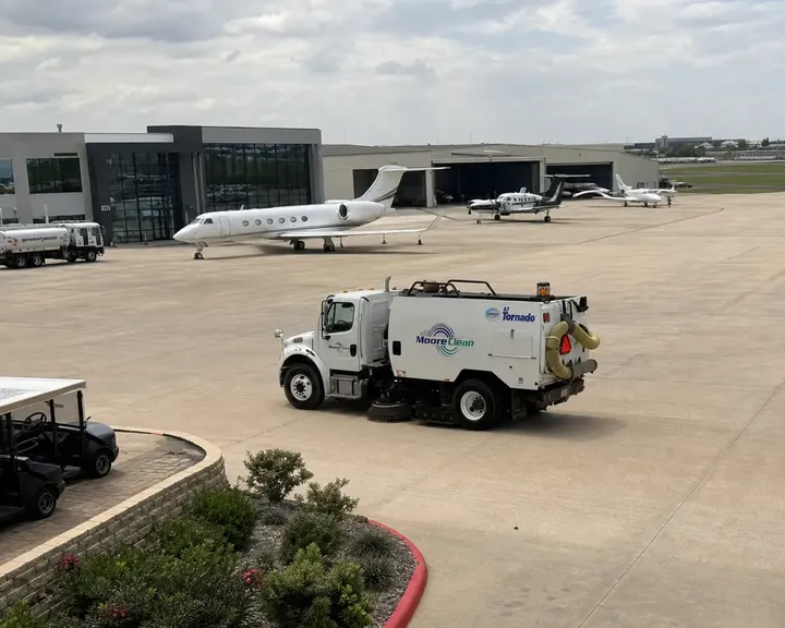 Moore Clean Schwarze A7 sweeper working a corporate FBO ramp with business jets and hangars