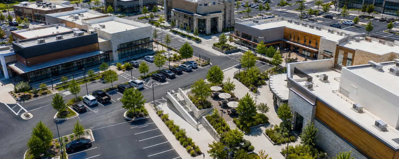Drone view of an upscale shopping complex parking lot with landscaped islands