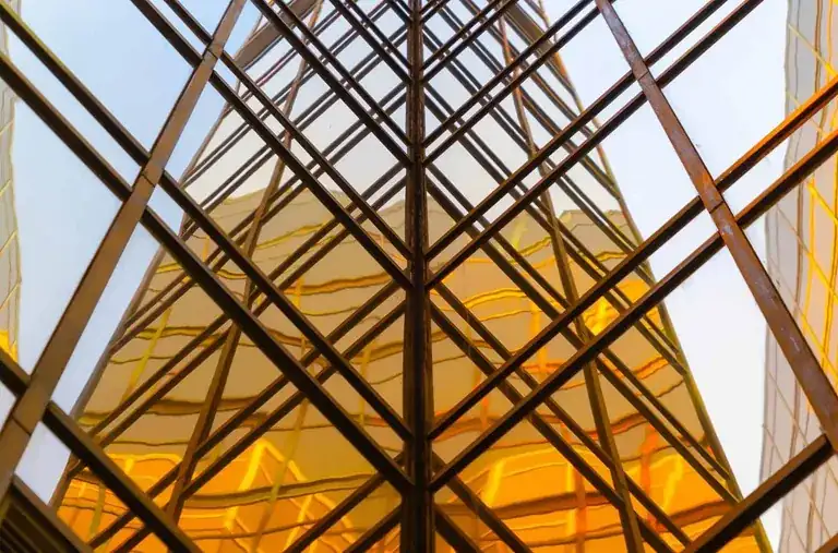 Glass curtain wall of an office tower reflecting golden light