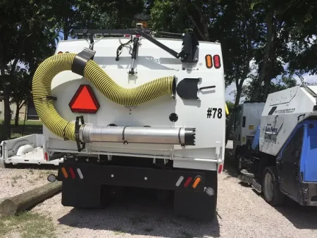 The back of street sweeping truck with attached hose